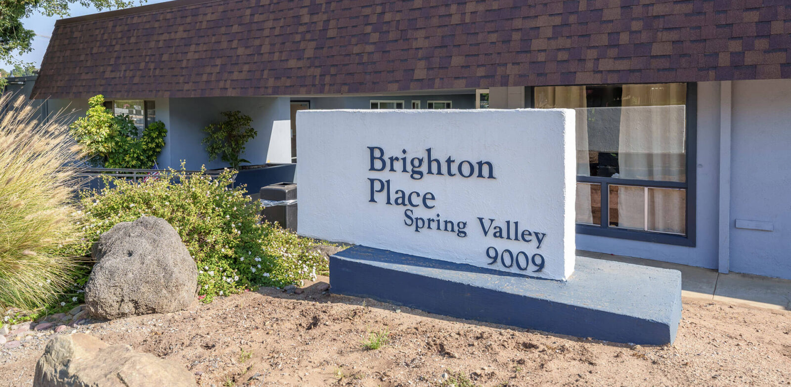 Sign for Brighton Place, located in Spring Valley, with landscaping and modern architecture.